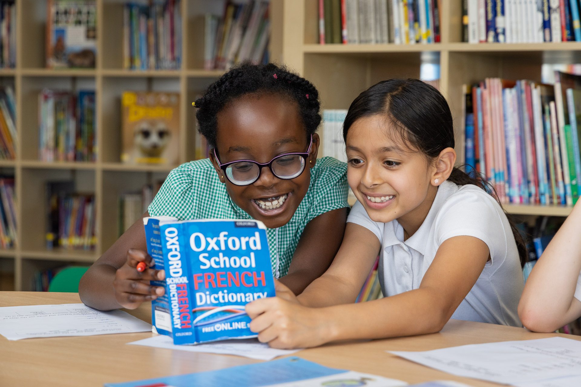 two girls looking at an Oxford French to English dictionary